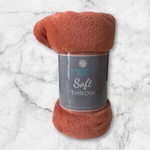 Comfort Bay soft throw blanket in a warm orange hue